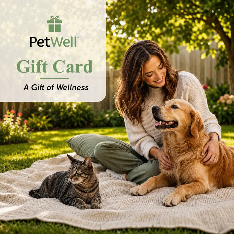 A woman sitting on a blanket in a sunny backyard with a golden retriever and a tabby cat. A white overlay in the top left reads 'PetWell Gift Card: A Gift of Wellness' with the PetWell logo.