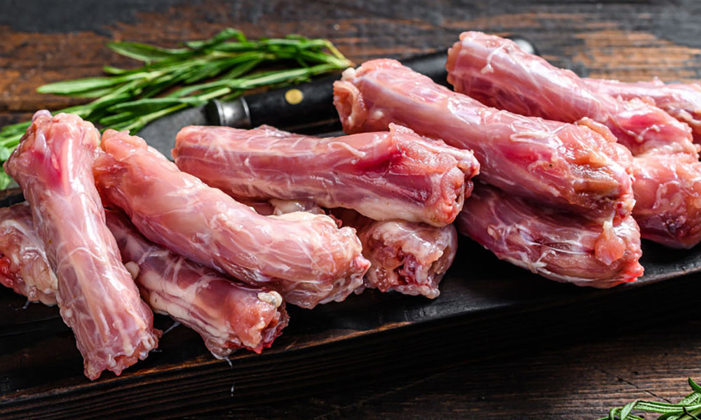 Fresh, raw Chicken Necks on a timber table